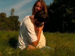 Legal age teenagers like French kissing with every other in open air on the grass